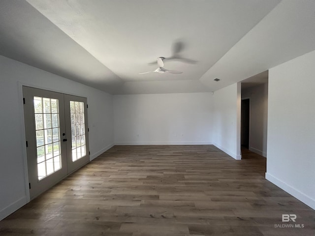 spare room featuring french doors, dark hardwood / wood-style floors, a tray ceiling, and ceiling fan