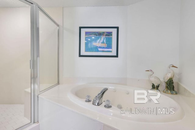 bathroom featuring a shower stall and a garden tub
