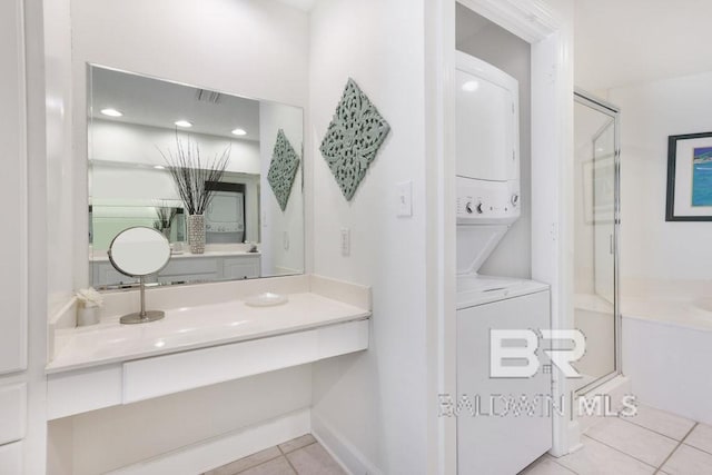 full bath with vanity, tile patterned floors, stacked washer / drying machine, and a stall shower
