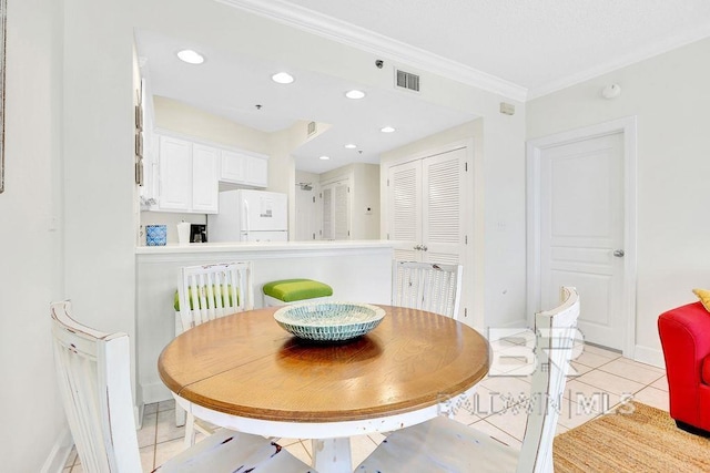 dining area with crown molding, baseboards, light tile patterned flooring, and visible vents