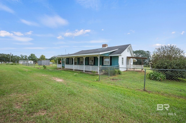 view of front of property featuring covered porch, a chimney, fence, and a front yard