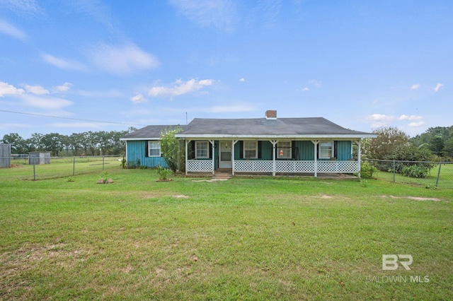 view of front facade featuring a front lawn, a chimney, and fence