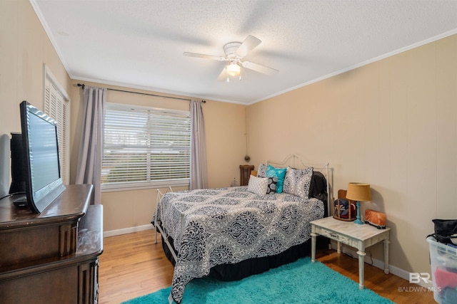 bedroom with ceiling fan, crown molding, and hardwood / wood-style flooring