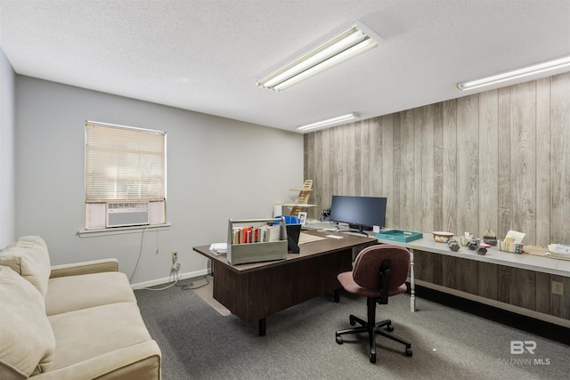 carpeted home office featuring wooden walls and a textured ceiling