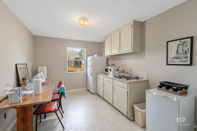 kitchen with refrigerator, a textured ceiling, and white refrigerator