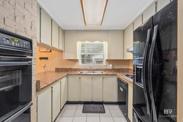 kitchen featuring cream cabinets, light tile floors, and black appliances