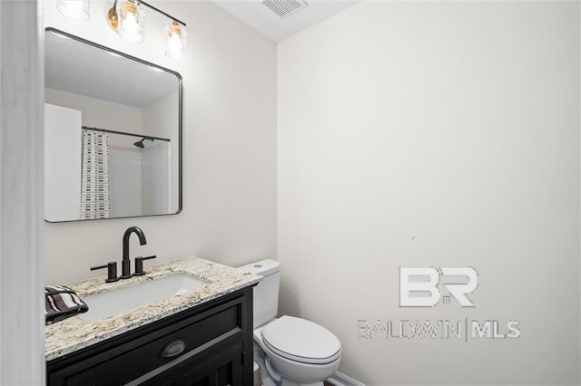 bathroom featuring a shower with curtain, vanity, and toilet