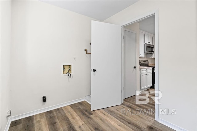 washroom with hookup for a washing machine and hardwood / wood-style flooring