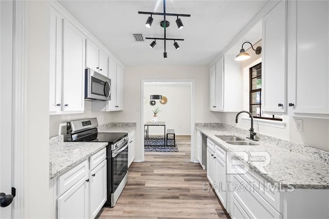 kitchen with sink, white cabinets, and appliances with stainless steel finishes