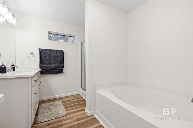 bathroom featuring plus walk in shower, hardwood / wood-style floors, and vanity