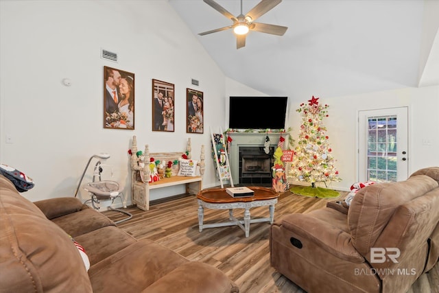 living room with ceiling fan, light wood-type flooring, and high vaulted ceiling