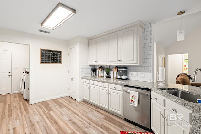 kitchen featuring washer and clothes dryer, dishwasher, light stone countertops, and backsplash