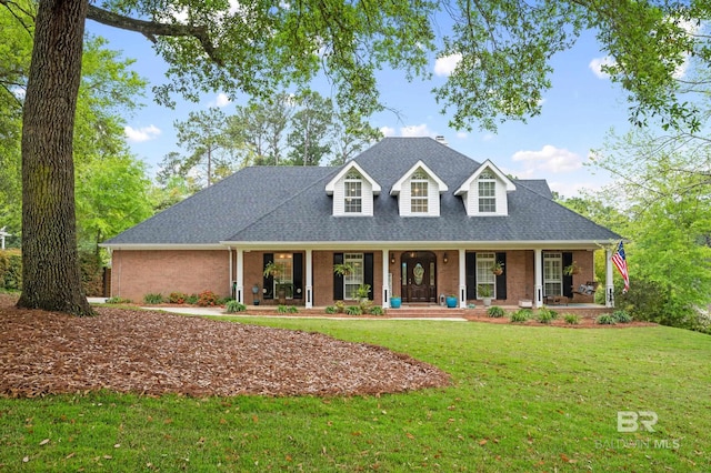 cape cod-style house featuring a front yard and a porch