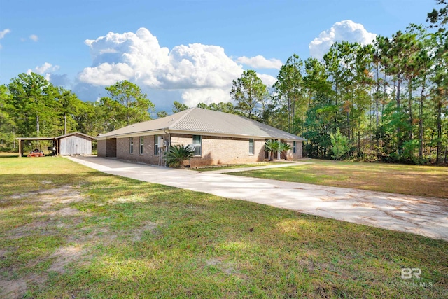 view of front of property featuring a front lawn and a storage unit