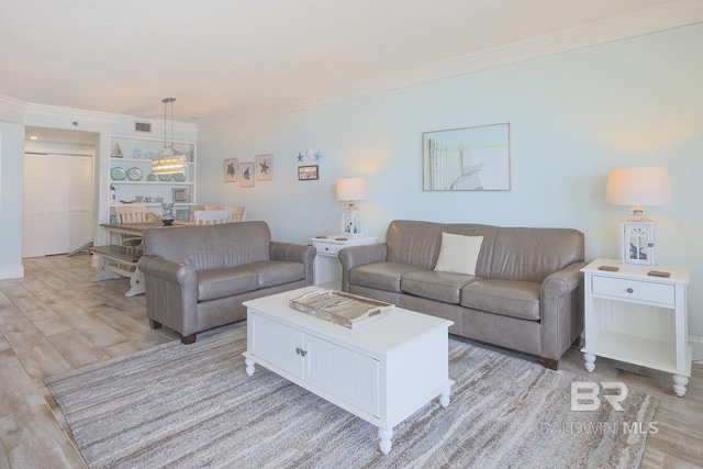living room featuring light wood-type flooring, visible vents, a chandelier, and crown molding