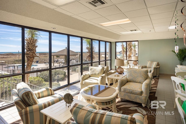 living room featuring visible vents, tile patterned flooring, and a paneled ceiling
