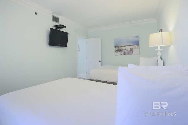 unfurnished bedroom with ornamental molding and visible vents