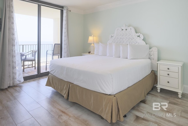 bedroom featuring expansive windows, access to exterior, crown molding, and light wood-style flooring