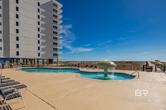 community pool with fence and a patio