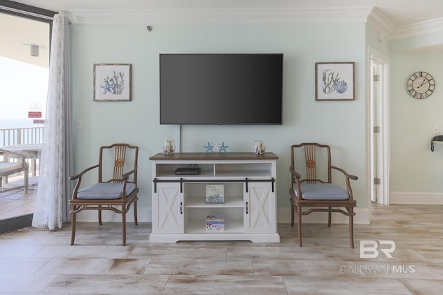 living area with baseboards, crown molding, a healthy amount of sunlight, and light wood-type flooring