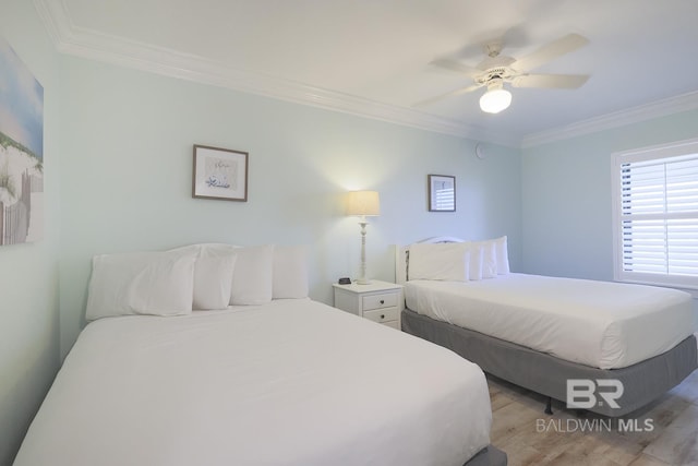bedroom featuring crown molding, light wood finished floors, and ceiling fan