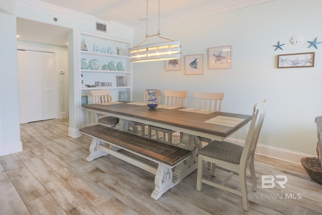 dining space featuring ornamental molding, baseboards, light wood-style floors, and visible vents