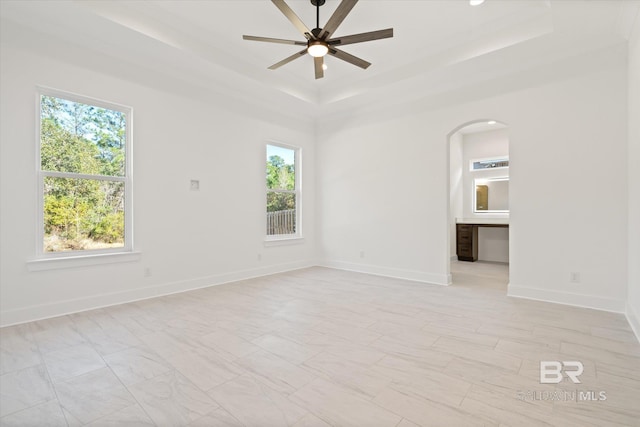 unfurnished room with a raised ceiling and ceiling fan