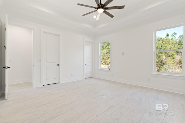 interior space featuring multiple windows, a tray ceiling, and ceiling fan