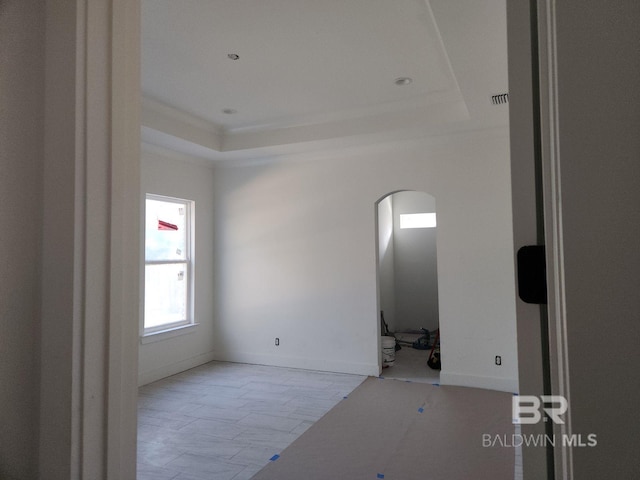 unfurnished room featuring a tray ceiling