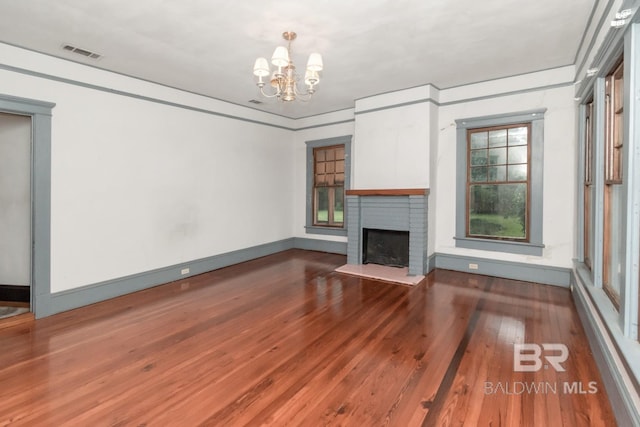 101 S Carlen St, Mobile, AL 36606 - unfurnished living room featuring hardwood / wood-style floors, a chandelier, and a brick fireplace