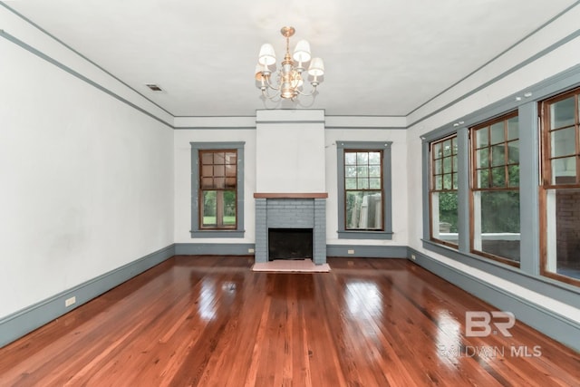 101 S Carlen St, Mobile, AL 36606 - unfurnished living room with a chandelier, hardwood / wood-style flooring, and a brick fireplace