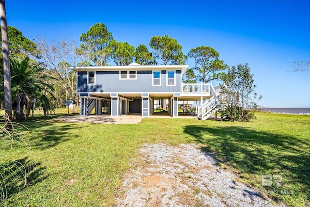 view of front of house featuring a water view, a front yard, and a carport