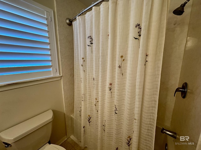 bathroom featuring curtained shower and toilet