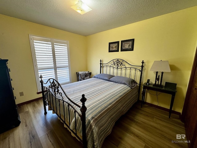 bedroom featuring hardwood / wood-style flooring and a textured ceiling