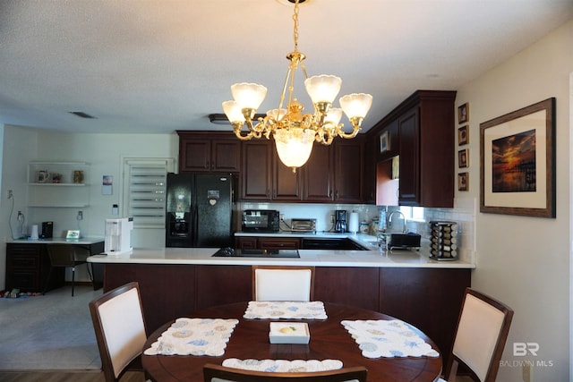 kitchen featuring decorative light fixtures, black appliances, decorative backsplash, a notable chandelier, and kitchen peninsula