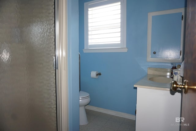 bathroom featuring vanity, toilet, and a shower with door