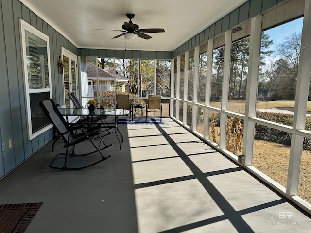 unfurnished sunroom with ceiling fan