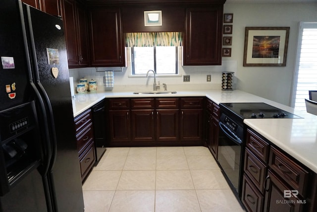 kitchen featuring tasteful backsplash, light tile patterned floors, sink, and black appliances