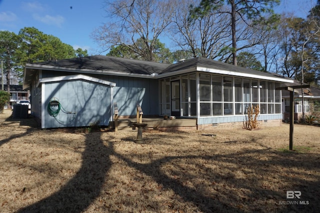 rear view of house with a yard, central AC, and a sunroom