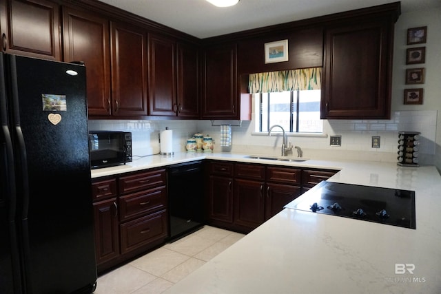 kitchen with sink, light tile patterned floors, black appliances, and decorative backsplash