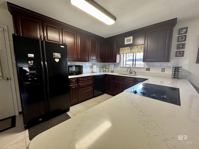 kitchen featuring sink, light tile patterned floors, black appliances, and decorative backsplash