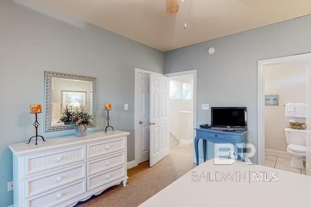 carpeted bedroom featuring ensuite bath and ceiling fan