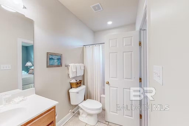 bathroom featuring toilet, tile floors, and vanity