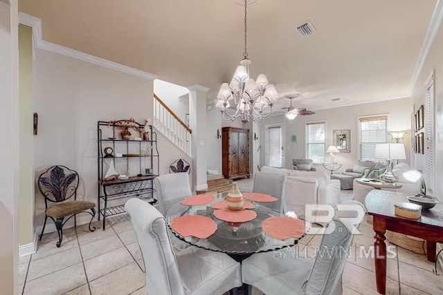 tiled dining area with decorative columns, ceiling fan with notable chandelier, and crown molding