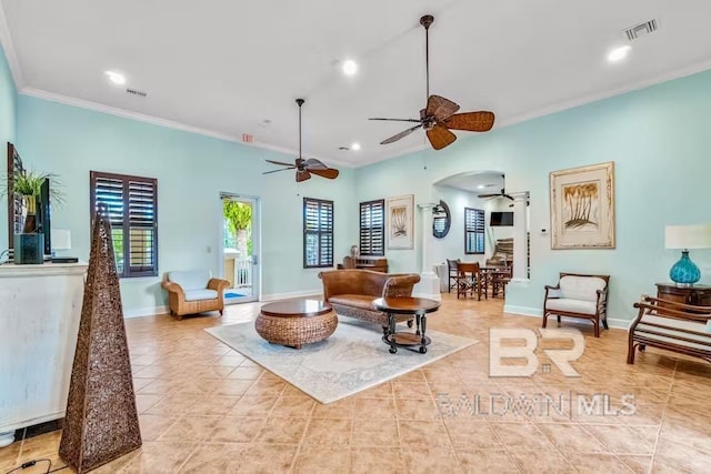 living room with ceiling fan, crown molding, and light tile floors