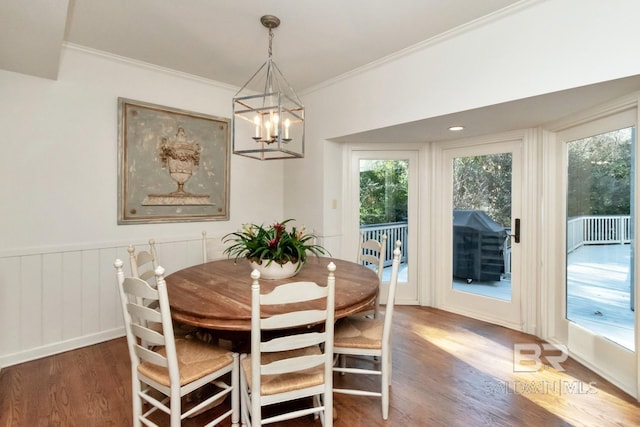 dining area featuring dark hardwood / wood-style floors, crown molding, and an inviting chandelier