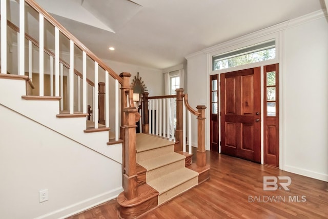 foyer entrance with wood-type flooring and ornamental molding