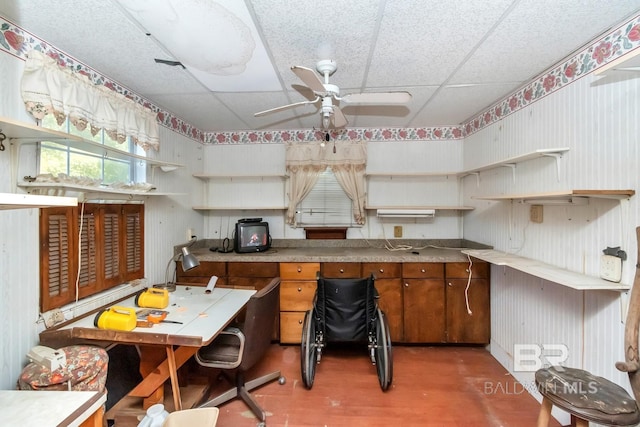 kitchen featuring ceiling fan and a drop ceiling