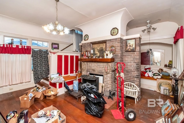 living room featuring lofted ceiling, ceiling fan with notable chandelier, and wood-type flooring