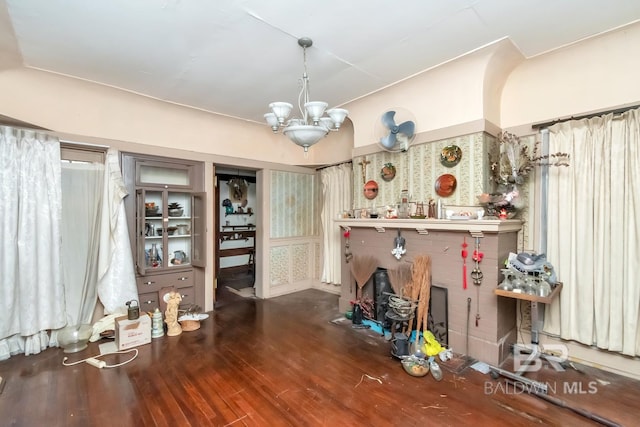 miscellaneous room with wood-type flooring and an inviting chandelier